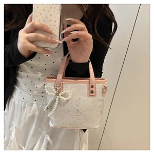 Détail du sac seau à imprimé papillon blanc avec garniture rose et nœud perlé