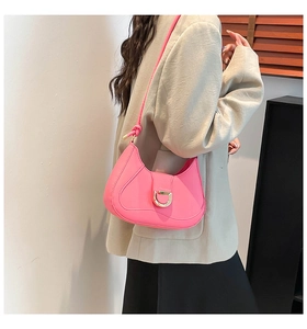 On-shoulder view of a bright pink hobo bag with a gold D-buckle and stitched details
