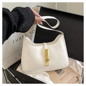 Detail of white leather hobo bag with gold metal buckle and chain in a gift box