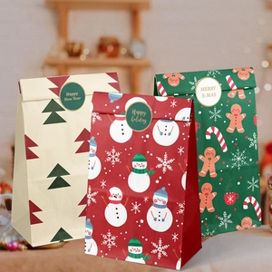 Trois sacs cadeaux de Noël en papier avec motifs festifs bonhomme de neige et pain d'épices