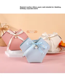 Close-up of three elegant leather wedding favor bags with silk ribbons and pearls