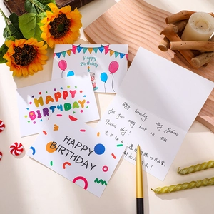 Detail einer Geburtstagskarte mit Regenbogenmotiven und zweisprachigen Grüßen