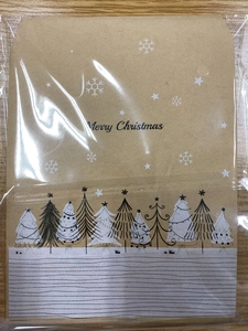 Nahaufnahme von braunem Weihnachts-Kraftumschlag mit Tannenbaummuster auf Holztisch