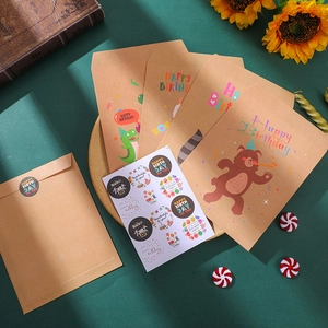Macro detail of kraft paper birthday envelopes with animal illustrations and stickers