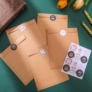 Close-up of kraft paper envelopes with colorful happy birthday stickers and floral decor