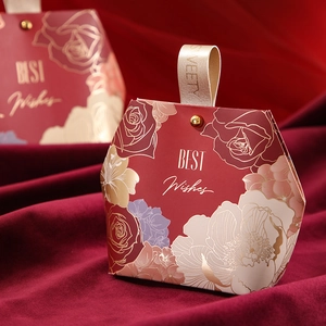 Red trapezoid wedding candy box with gold floral patterns and ribbon handle