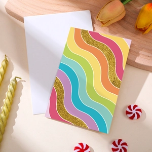 Biglietto d'auguri a onde arcobaleno con dettagli dorati glitterati e busta bianca