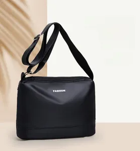 Vue détaillée du nylon imperméable et du logo FASHION sur un sac à bandoulière noir moderne