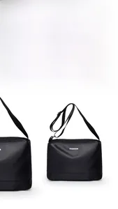Détail du sac bandoulière noir imperméable avec fini mat et imprimé texte de mode
