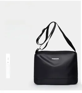 Détail du sac bandoulière en nylon imperméable avec lettrage FASHION et double fermeture