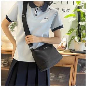 Détail d'un sac bandoulière en nylon noir imperméable avec large sangle réglable
