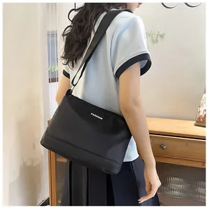 Détail de la bandoulière réglable sur un sac à bandoulière noir étanche pour femme