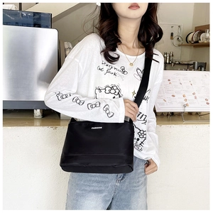 Détail du sac bandoulière étanche en nylon avec logo Fashion dans un café
