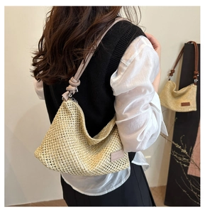 Détail d'un sac hobo en paille bohème avec tissage ajouré et bandoulière en cuir noué