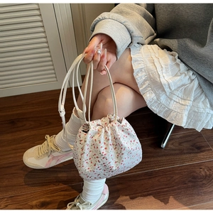 Detail of floral drawstring tote bag with elegant drawstring closure and shoulder strap