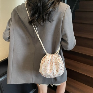 Floral drawstring crossbody bag for women with pink flower patterns and slim shoulder straps