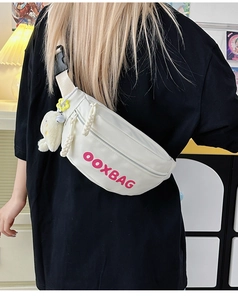 Détail du sac bandoulière blanc en nylon avec lettrage rose et breloques peluche