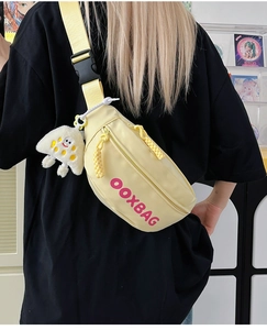 Détail du sac bandoulière en nylon jaune avec lettrage rose et breloque méduse