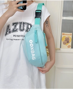 Détail de la sacoche bandoulière bleu menthe avec logo OOXBAG et boucle en plastique durable