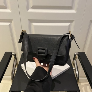 Minimalist black lychee leather shoulder bag with magnetic flap and square buckle detail