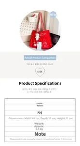 Detail view of red nylon tote bag with white apple print and plush bear keychain accessory