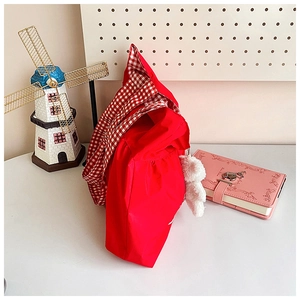 Detail of red travel tote with red white checkered liner and cute white plush bear charm