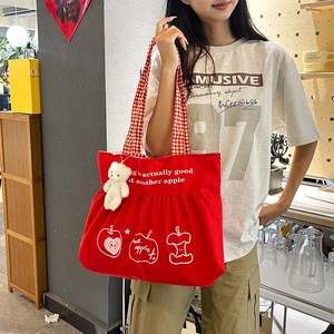 Red canvas apple tote bag with checkered handles and a white bear plush pendant