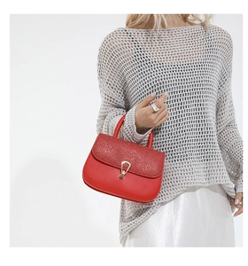 Détail du sac à main en cuir rouge avec rabat à paillettes et fermoir en métal doré en U