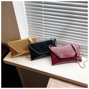 Detailed view of envelope bags with vintage texture and golden chain straps