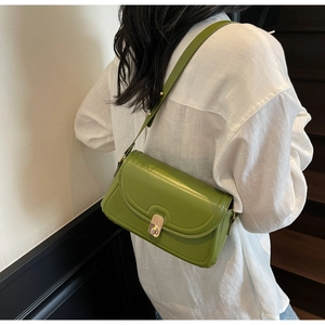 Gros plan d'un sac bandoulière vert herbe en cuir avec boucle en métal doré élégant