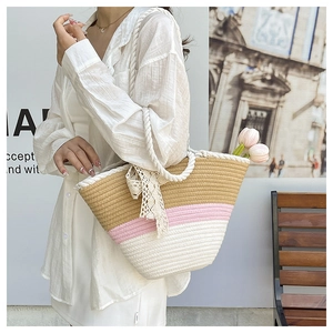 Detail of summer straw tote bag with tricolor patchwork, lace bow and cotton rope handle