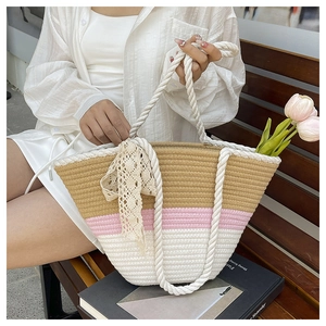 Detail of hand-woven bucket bag with contrast stitching and elegant lace ribbon decoration