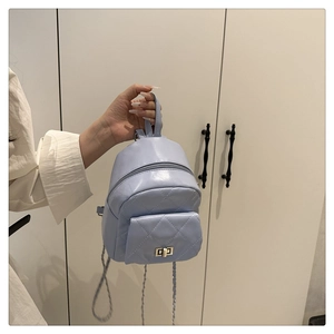 Detail of light blue mini backpack with quilted pattern and metal turn-lock pocket