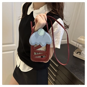 Detail of creative cherry cake shoulder bag with blue wavy flap and leather strap