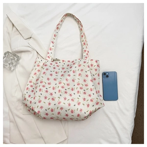 Detailed overhead view of floral canvas tote bag with pink flower pattern and straps
