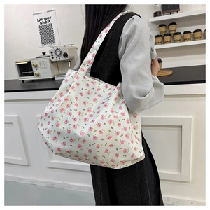 Floral canvas tote bag with pink flower pattern shown in a modern lifestyle setting