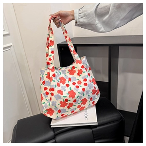 Close-up of floral canvas tote bag featuring red and blue flower patterns on beige fabric