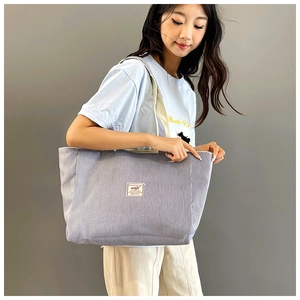 Close-up of grey corduroy tote bag featuring striped texture and durable shoulder strap
