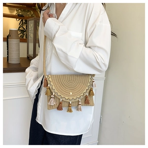 Detail shot of a woven saddle bag featuring bohemian fringe accents and tassel decorations