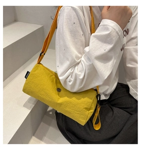 Détail du sac cylindre en nylon jaune avec sangle réglable et étiquette Fanvissa