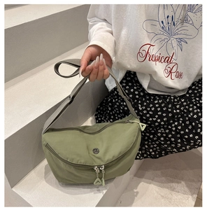 Detail of matcha green nylon crescent bag with large triangular zipper pull and wide strap