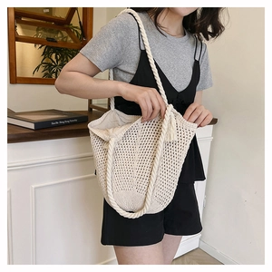 Détail d'un sac cabas tissé blanc ajouré avec une bandoulière en corde de coton épais