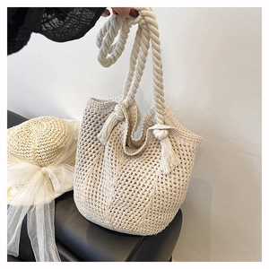 Detailed close-up of ivory woven bucket bag featuring hollow mesh texture and rope handle