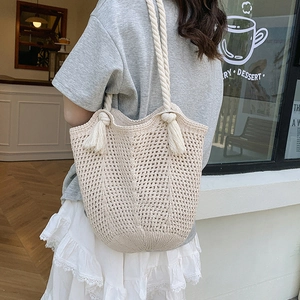 Beige oversized woven crochet tote bag with tassel straps for summer beach vacations
