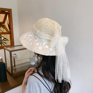 Summer woven straw sun hat with white lace embroidery and large mesh bow detail