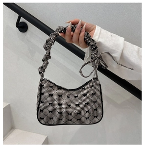Close-up of checkered quilted bag with black mini bows and ruffled bubble handle