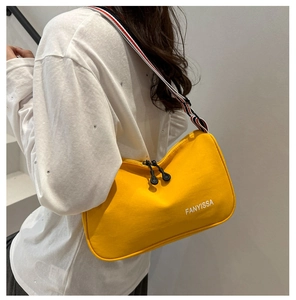 Détail du sac hobo en tissu jaune avec imprimé FANYISSA et bandoulière rayée tricolore