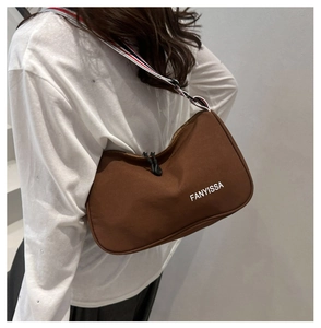 Vue détaillée du sac besace en nylon marron avec sa bandoulière rayée tricolore