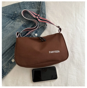 Brown crossbody bag with striped strap shown next to a smartphone for size reference