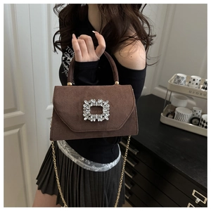 Close-up of deep brown suede handbag featuring a luxury square rhinestone buckle detail
